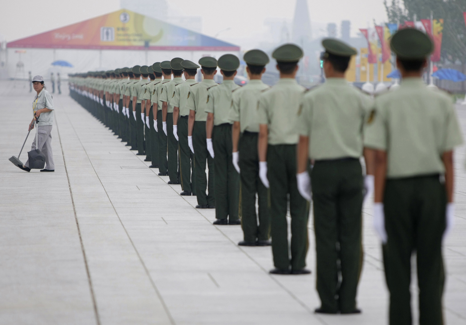 Китайски параваоенни служители в  редица до честачка. Олимипийски игри в Пекин  2008