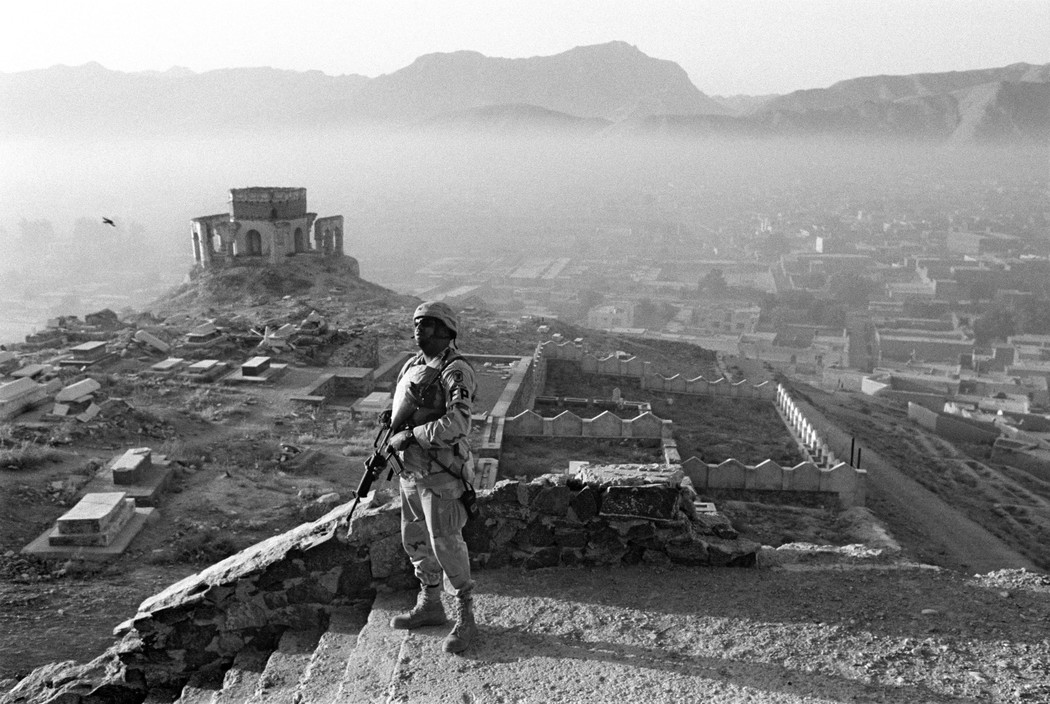 AFGHANISTAN. Kabul. An American GI on a dawn patrol over the hill housing the Nader Shah tomb overlooking the capital.
