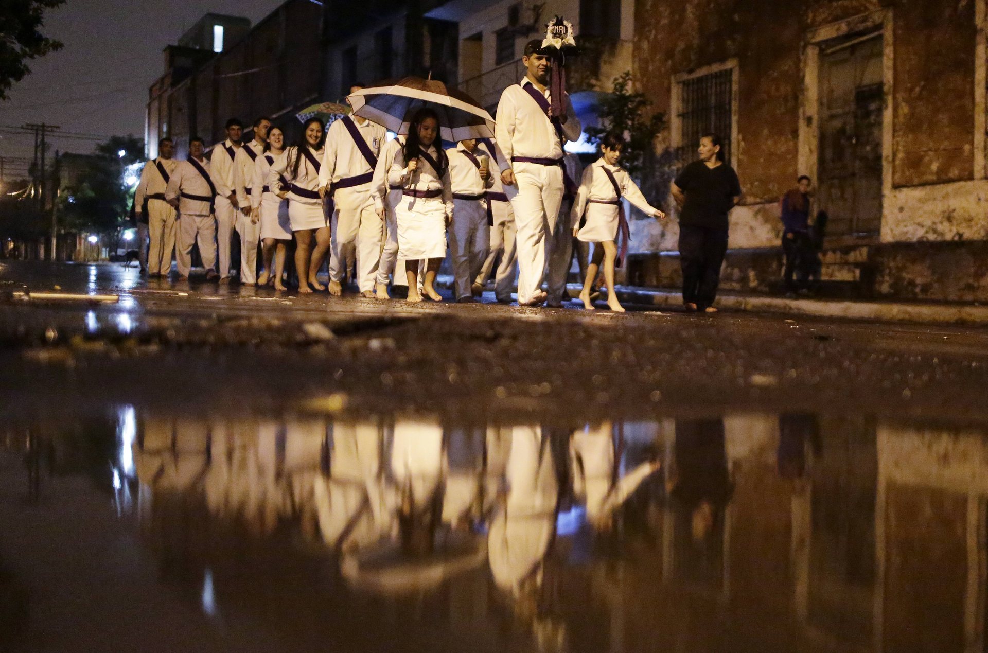Асунсион, Парагвай Католици ходят боси в дъжда, пеещи религиозни песни по време на шествие из града Фото: Хорхе Саенц / AP