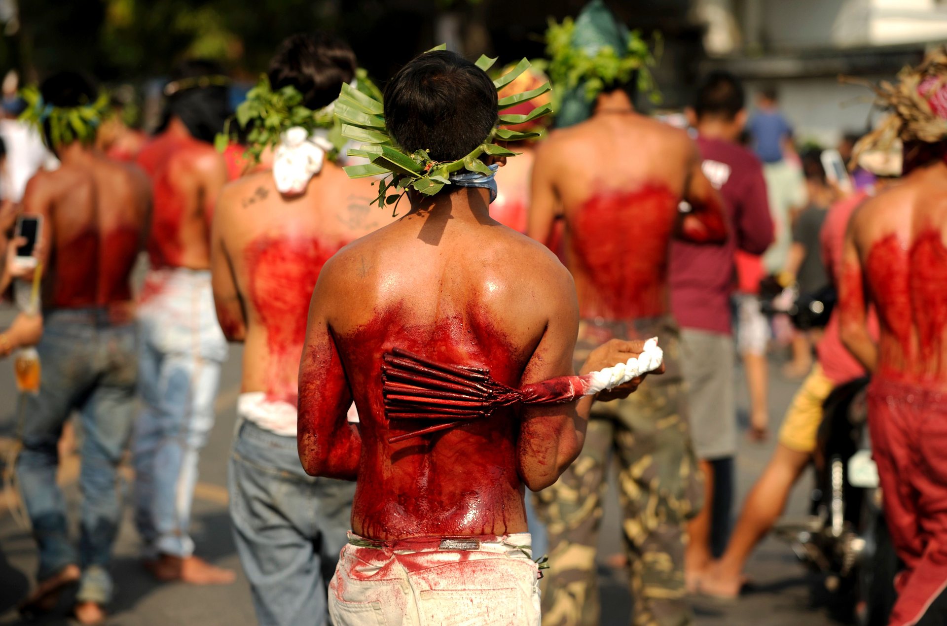 Пампанга, Филипини Поклонници си удрят с бамбуков камшик гърба им по време на възстановка на разпятието Снимка: Noel Celis / AFP / Getty Images 