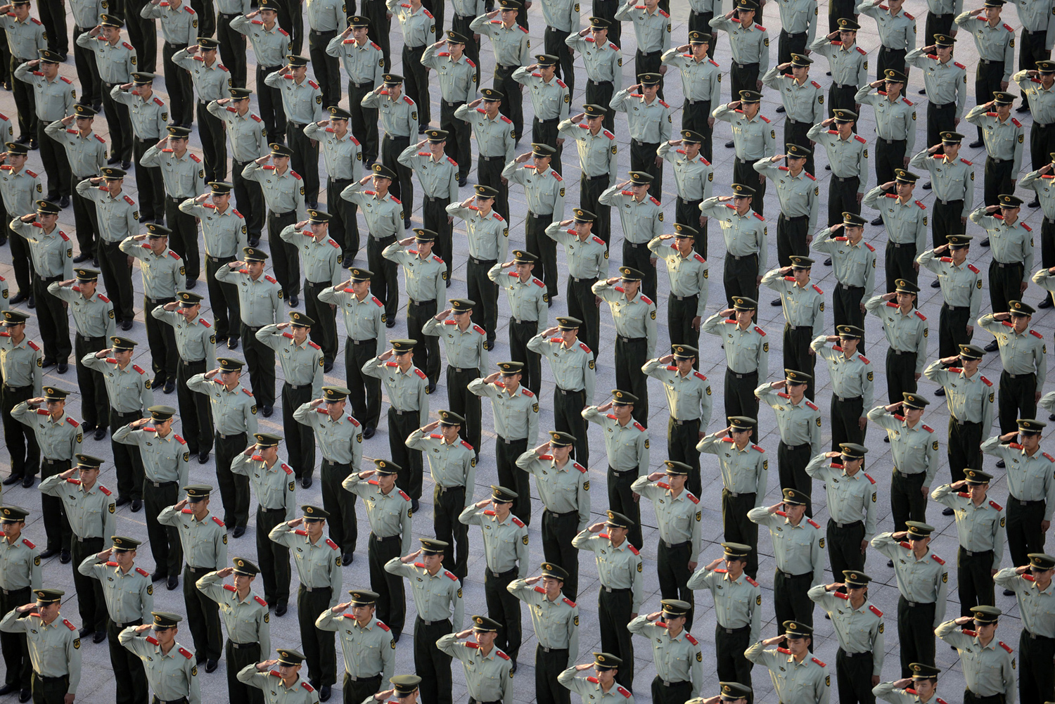 Паравоенни полицаи отдават чест на церемонията по вдигане на знамето, по случай 65-ата годишнина от основаването на Китайската народна република, в Нанкин, провинция Дзянсу, на 1 октомври 2014 година.